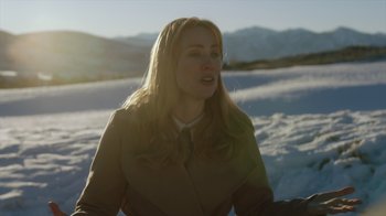 Movie still from “Deborah” (2022), directed by Noga Pnueli – A woman in a brown jacket is standing in the snow; Close Up shot, Over the shoulder angle