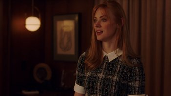 Movie still from “Deborah” (2022), directed by Noga Pnueli – A woman with red hair wearing a black and white dress; Medium shot, Over the shoulder angle