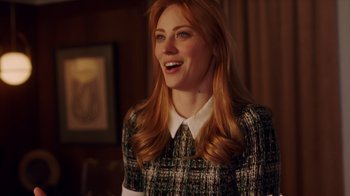 Movie still from “Deborah” (2022), directed by Noga Pnueli – A woman with long red hair wearing a green and white dress; Medium shot, Over the shoulder angle