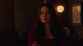 Movie still from “Deborah” (2022), directed by Noga Pnueli – A woman standing in a room with her arms crossed; Close Up shot, Over the shoulder angle