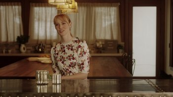 Movie still from “Deborah” (2022), directed by Noga Pnueli – A woman sitting at a table in front of two glasses of water; Medium shot, Low angle