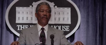 Movie still from “Deep Impact” (1998), directed by Mimi Leder – An older man in a gray suit and tie; Close Up shot, Low angle