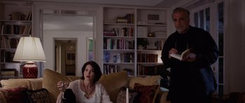 Movie still from “Deep Impact” (1998), directed by Mimi Leder – A man and a woman sitting in a living room; Medium shot, Over the shoulder angle