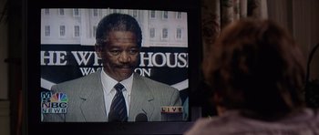 Movie still from “Deep Impact” (1998), directed by Mimi Leder – A man in a suit and tie is on a television screen; Close Up shot, Over the shoulder angle