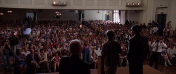 Movie still from “Deep Impact” (1998), directed by Mimi Leder – A crowd of people in front of a microphone; Wide shot, High angle