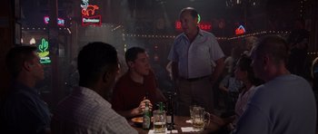 Movie still from “Deep Impact” (1998), directed by Mimi Leder – A group of men sitting at a table in a bar; Medium shot, Over the shoulder angle
