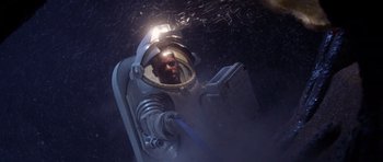 Movie still from “Deep Impact” (1998), directed by Mimi Leder – A man in a spacesuit with a light on his head; Medium shot, Overhead angle