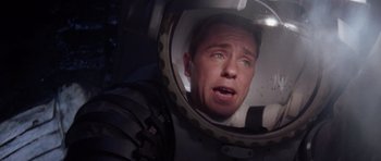 Movie still from “Deep Impact” (1998), directed by Mimi Leder – A man in a space suit looking into a mirror; Medium shot, Overhead angle