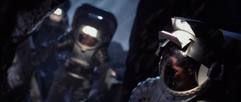 Movie still from “Deep Impact” (1998), directed by Mimi Leder – Two people in spacesuits in a dark space; Close Up shot, Overhead angle