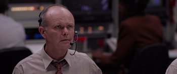 Movie still from “Deep Impact” (1998), directed by Mimi Leder – An older man wearing a headset in front of a television; Close Up shot, Low angle