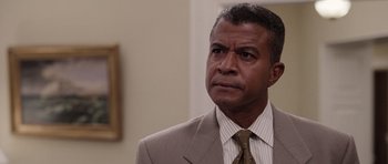 Movie still from “Deep Impact” (1998), directed by Mimi Leder – A man in a suit and tie looking to his left; Close Up shot, Over the shoulder angle