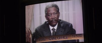 Movie still from “Deep Impact” (1998), directed by Mimi Leder – An older man in a suit and tie is sitting in front of a television; Close Up shot, High angle