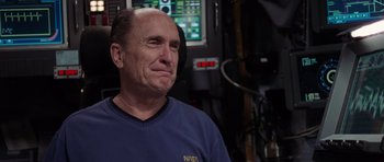 Movie still from “Deep Impact” (1998), directed by Mimi Leder – An older man in a blue shirt is sitting in front of a computer screen; Close Up shot, Over the shoulder angle