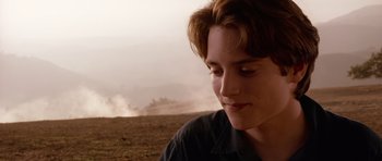 Movie still from “Deep Impact” (1998), directed by Mimi Leder – A young man is sitting in the middle of a field; Close Up shot, Over the shoulder angle