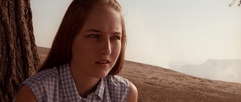 Movie still from “Deep Impact” (1998), directed by Mimi Leder – A young woman in a checkered shirt is sitting on a hill; Close Up shot, Over the shoulder angle