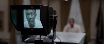 Movie still from “Deep Impact” (1998), directed by Mimi Leder – A television screen showing a man's face in front of a camera; Extreme Close Up shot, Over the shoulder angle