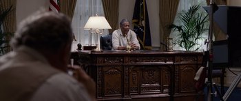 Movie still from “Deep Impact” (1998), directed by Mimi Leder – An older man sitting at a desk in an office; Medium shot, Low angle