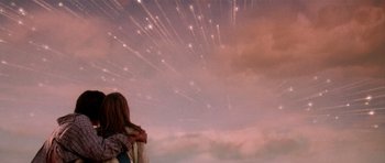Movie still from “Deep Impact” (1998), directed by Mimi Leder – A woman standing in front of a sky filled with lots of fireworks; Medium shot, Low angle