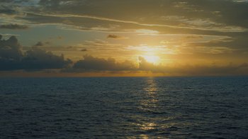Movie still from “Deep in the Heart: A Texas Wildlife Story” (2022), directed by Ben Masters – The sun is setting over a body of water; Extreme Wide shot, High angle