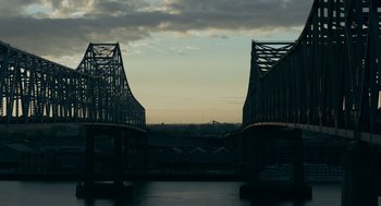 Movie still from “Deep Water” (2022), directed by Adrian Lyne – A view of a bridge that has two bridges on each side of it; Extreme Wide shot, High angle