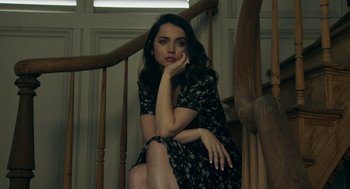Movie still from “Deep Water” (2022), directed by Adrian Lyne – A woman sitting on the bottom of a wooden stair case; Close Up shot, Low angle