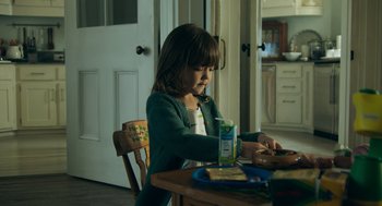 Movie still from “Deep Water” (2022), directed by Adrian Lyne – A little girl sitting at a table with food; Medium shot, Over the shoulder angle