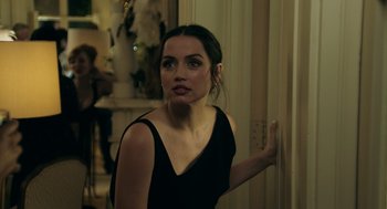 Movie still from “Deep Water” (2022), directed by Adrian Lyne – A woman in a black dress is standing in a room; Close Up shot, Over the shoulder angle