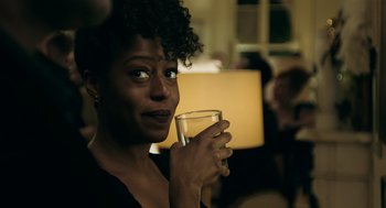 Movie still from “Deep Water” (2022), directed by Adrian Lyne – A woman holding a glass of water in her hand; Close Up shot, Over the shoulder angle