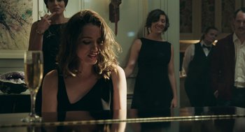 Movie still from “Deep Water” (2022), directed by Adrian Lyne – Two women are standing at a piano in a room; Medium shot, Over the shoulder angle