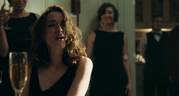 Movie still from “Deep Water” (2022), directed by Adrian Lyne – Two women standing in a room with one of them smiling; Close Up shot, Over the shoulder angle