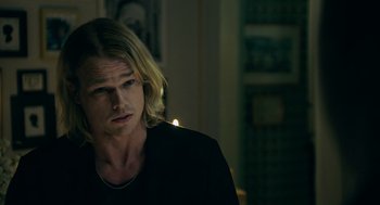 Movie still from “Deep Water” (2022), directed by Adrian Lyne – A man with blonde hair is sitting in a dark room; Close Up shot, Over the shoulder angle