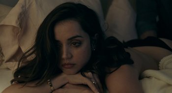 Movie still from “Deep Water” (2022), directed by Adrian Lyne – A beautiful young lady laying in bed with her hands on her chest; Close Up shot, High angle