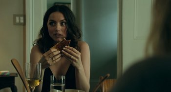 Movie still from “Deep Water” (2022), directed by Adrian Lyne – A woman sitting at a table eating a piece of bread; Close Up shot, Over the shoulder angle