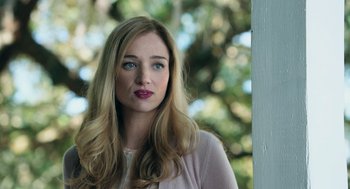Movie still from “Deep Water” (2022), directed by Adrian Lyne – A woman with long blonde hair wearing a pink shirt; Close Up shot, Low angle
