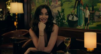Movie still from “Deep Water” (2022), directed by Adrian Lyne – A woman sitting in front of a glass of wine; Close Up shot, Over the shoulder angle