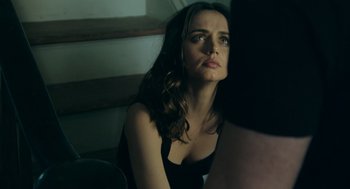 Movie still from “Deep Water” (2022), directed by Adrian Lyne – A woman sitting on a chair in front of a window; Close Up shot, Over the shoulder angle