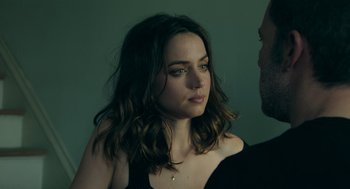 Movie still from “Deep Water” (2022), directed by Adrian Lyne – A young woman with long brown hair looking at a man; Close Up shot, Over the shoulder angle