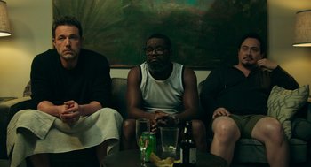 Movie still from “Deep Water” (2022), directed by Adrian Lyne – A group of people sitting around a table with drinks on it; Medium shot, High angle