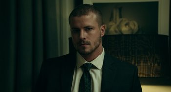 Movie still from “Deep Water” (2022), directed by Adrian Lyne – A person wearing a suit and tie; Close Up shot, Low angle