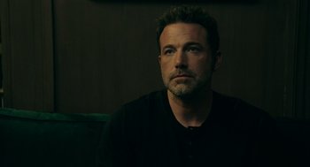 Movie still from “Deep Water” (2022), directed by Adrian Lyne – A person sitting on a couch; Close Up shot, Over the shoulder angle