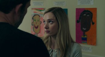 Movie still from “Deep Water” (2022), directed by Adrian Lyne – A young woman is looking at a young man in front of a wall of pictures; Close Up shot, Over the shoulder angle