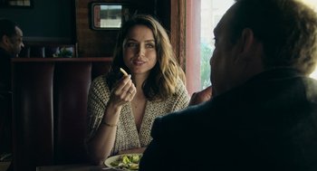 Movie still from “Deep Water” (2022), directed by Adrian Lyne – A woman sitting in front of a plate of food; Close Up shot, Over the shoulder angle