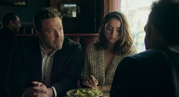Movie still from “Deep Water” (2022), directed by Adrian Lyne – A man and a woman sitting in front of a plate of food; Medium shot, Over the shoulder angle