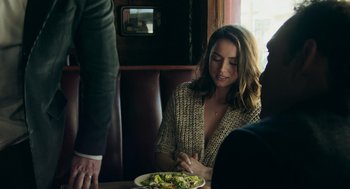 Movie still from “Deep Water” (2022), directed by Adrian Lyne – A woman sitting in front of a plate of food; Medium shot, Over the shoulder angle