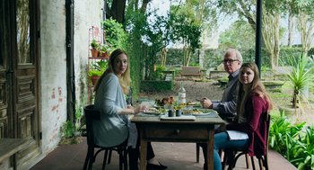 Movie still from “Deep Water” (2022), directed by Adrian Lyne – A man and a woman sitting at a table with food; Wide shot, Over the shoulder angle