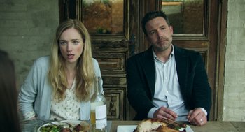 Movie still from “Deep Water” (2022), directed by Adrian Lyne – A man and a woman sitting at a dinner table; Medium shot, High angle