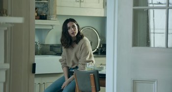 Movie still from “Deep Water” (2022), directed by Adrian Lyne – A woman sitting on a chair in a kitchen; Medium shot, Over the shoulder angle