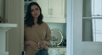 Movie still from “Deep Water” (2022), directed by Adrian Lyne – A woman standing in a kitchen holding a wine glass; Medium shot, Over the shoulder angle