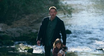 Movie still from “Deep Water” (2022), directed by Adrian Lyne – A man and a little girl are walking by a river; Medium shot, High angle