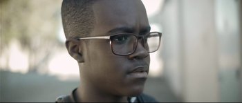 Movie still from “Upstream Color” (2013), directed by Shane Carruth – A person wearing glasses; Close Up shot, Low angle